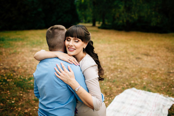 Fototapeta premium Happy and young pregnant couple hugging in nature