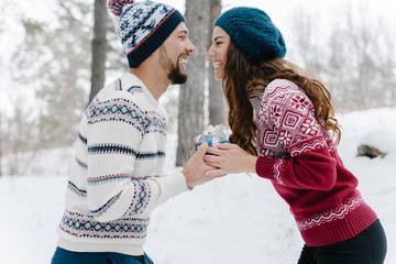 Attractive cute girl gives a gift to her beloved man for the valentine’s day 
