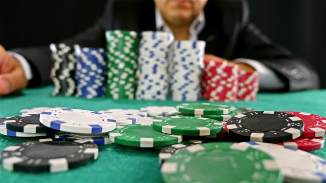 A gambler at a poker table doing fold