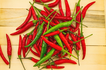 Spicy hot peppers green and red in a wooden box isolated on white background