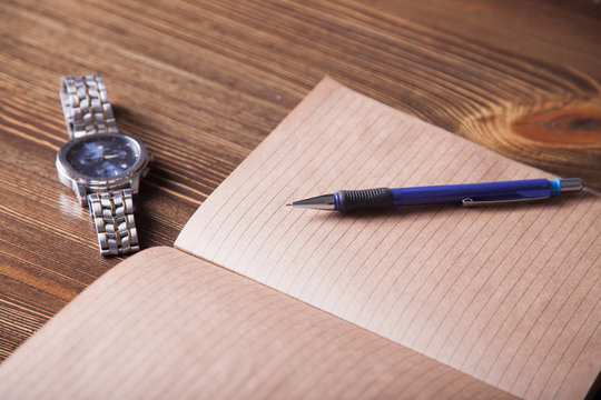 pencil and open notebook  on  a table, selective focus