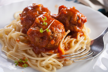 meatballs in tomato sauce from spaghetti in a plate on a table, selective focus