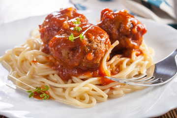 meatballs in tomato sauce from spaghetti in a plate on a table, selective focus