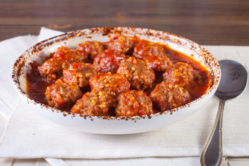 meatballs in tomato sauce in a bowl on a table, selective focus