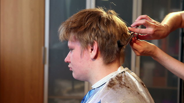 Hairdresser cuts client with scissors