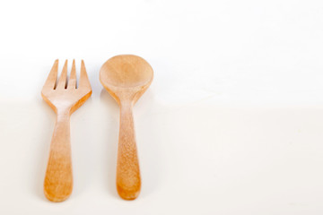 brown wooden spoons and forks on white background,selective focus