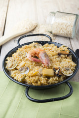 Vegetable paella with seafood on a wooden background