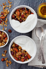 Homemade yogurt bowl with granola on black table, healthy and diet breakfast, top view