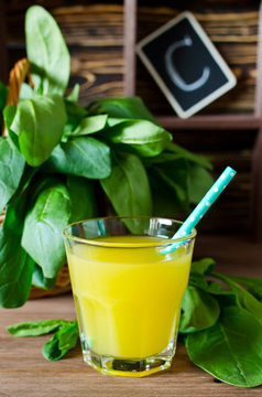 Fresh spinach in a basket and orange juice on the table. Source