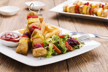 Grilled chicken skewers with pineapple, peppers and onions serve