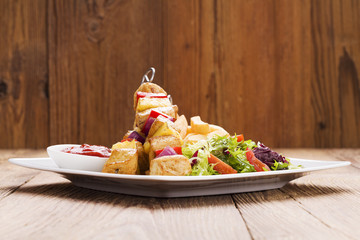 Grilled chicken skewers with pineapple, peppers and onions serve