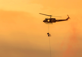 Fototapeta na wymiar soldiers climb down from helicopter in military mission.