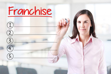 Business woman writing blank Franchise list. Office background. 
