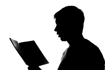 Young man reading a book - silhouette