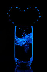Вода в бокале и капли в виде сердца, на чёрном фоне