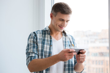 Handsome smiling male using smartphone