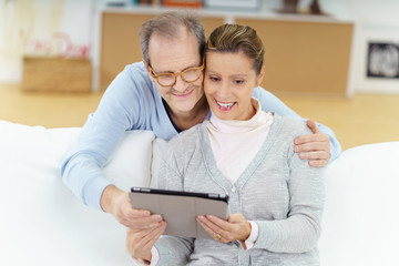 älteres paar schaut zuhause auf das tablet
