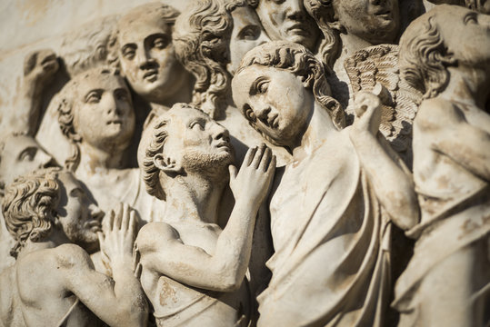Mensch und Engelfigur aus dem  Fries mit der Darstellung der Apokalypse an der Fassade des Doms von Orvieto
