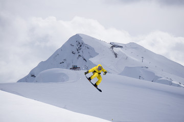 Flying snowboarder on mountains. Extreme sport.