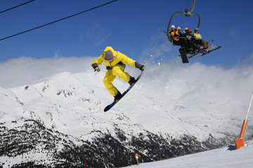 Flying snowboarder on mountains. Extreme sport.