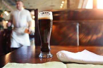 glass of dark beer in a restaurant interior