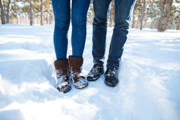 Male and female legs standing in winter park