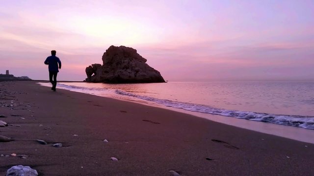 man running on the beach at sunrise