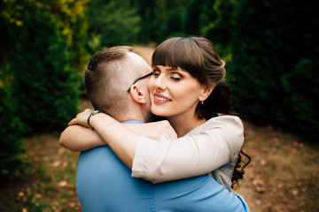 Fototapeta premium Happy and young pregnant couple hugging in nature