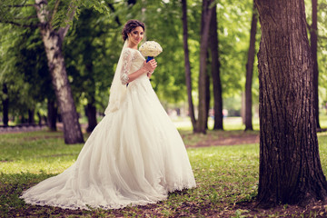 Obraz na płótnie Canvas Elegant bride in wedding dress with dipped hem in full length