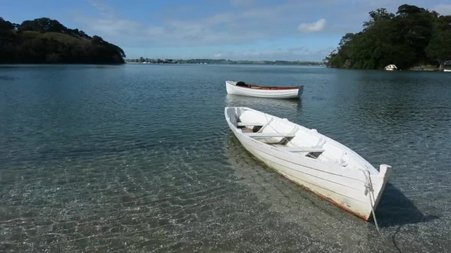 An old wooden dinghy row boats mooring in Leigh, New Zealand