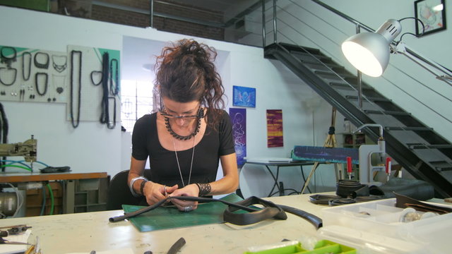 Young eco jewelry maker creating artwork in her atelier