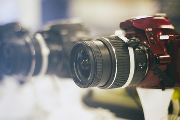 Fototapeta na wymiar Photograph of a red reflex camera on a blurred background