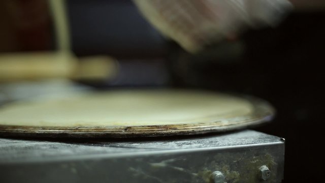The chef uses roller knife to cut off the excess dough, he cooks pizza
