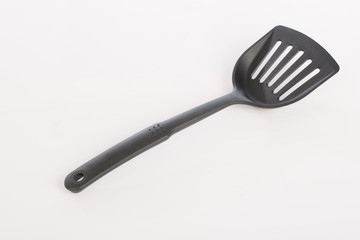 a flipper used for frying ,spade of frying pan on white background ,selective focus
