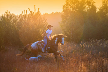 Obraz na płótnie Canvas Girl riding on the red-and-white Appaloosa horse