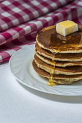 Stack of homemade pancakes with butter and honey