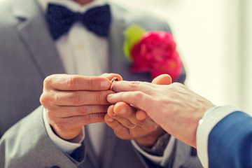 close up of male gay couple hands and wedding ring