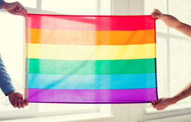 Fototapeta na wymiar close up of male gay couple holding rainbow flag