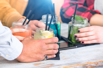 Group of friends drinking cocktails at fashion bar restaurants - Side view point of people hands with smartphone - Social gathering concept with addicted men and women - Vivid vintage filter with halo