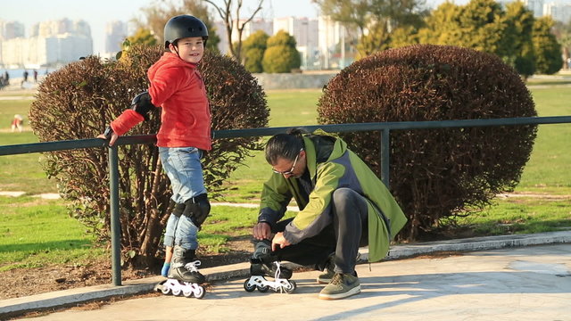 Young boy (9 years old) roller skating for the first time,Father helping and showing