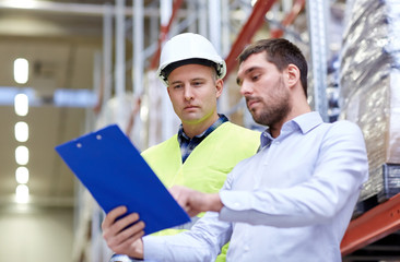 worker and businessmen with clipboard at warehouse