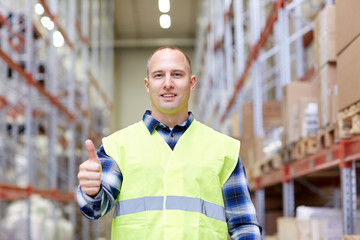 happy man showing thumbs up gesture at warehouse