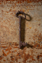 Old key on rusty metal background