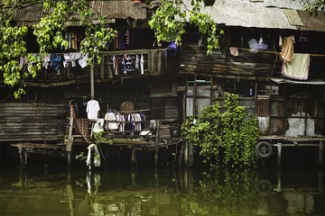 Poster BANGKOK-THAILAND-JAN 18: Riverside slums in Chao Phraya River on January 18 2014 Bangkok Thailand © photoaliona