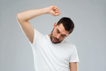 young making gallows gesture over gray background