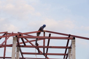 worker welding the steel to build the roof