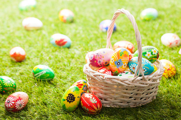 Unique hand painted Easter eggs in basket on grass
