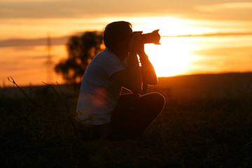 Fotograf fotografiert Sonnenuntergang und Landschaft Silhouette