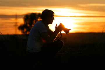 Fotograf fotografiert Sonnenuntergang und Landschaft Silhouette