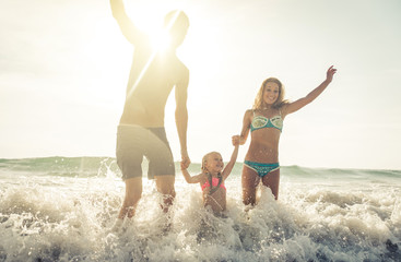 Obraz premium Happy family jumping in the water